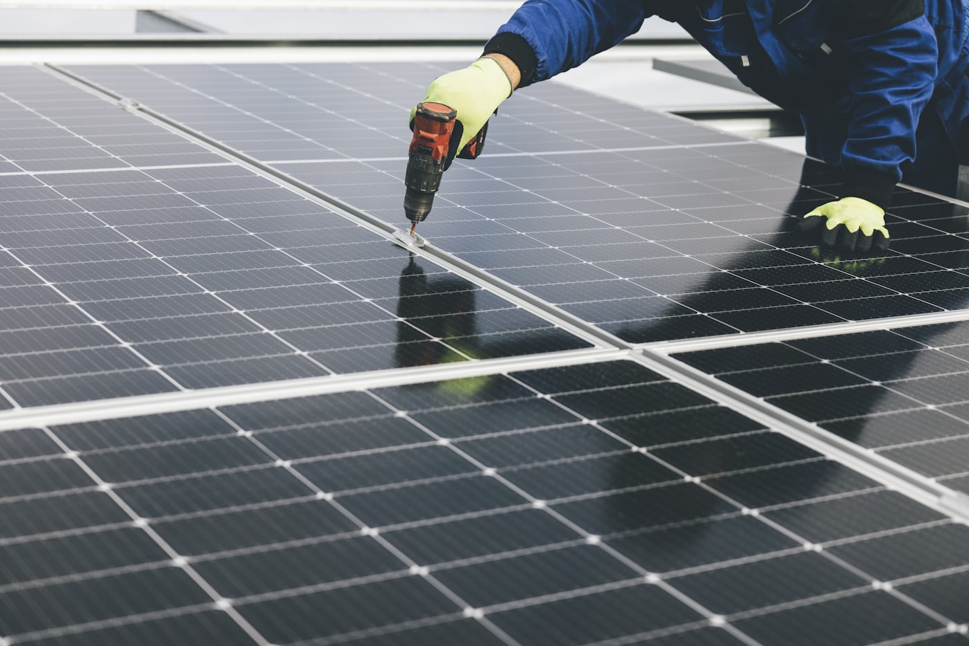 Installer fixing a solar module into its mounting rail